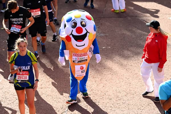 Members of the public finish during the 2021 Virgin Money London Marathon