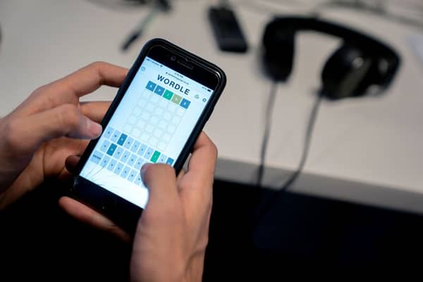 This photo illustration shows a person playing online word game “Wordle” on a mobile phone in Washington, DC on January 11, 2022 (Photo by STEFANI REYNOLDS/AFP via Getty Images)