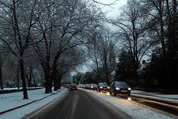 Cars drive on snowy roads.