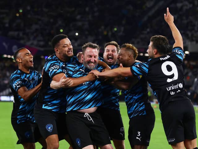 Lee Mack celebrates his goal with World XI teammates including Steven Bartlett (left-centre)