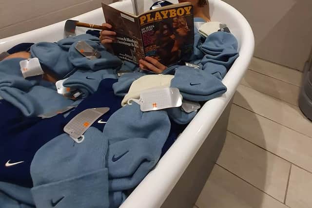 Depop entrepreneur Callum Massey poses in a bath full of deadstock nike beanies from 2002 that he purchased and resold on the site.