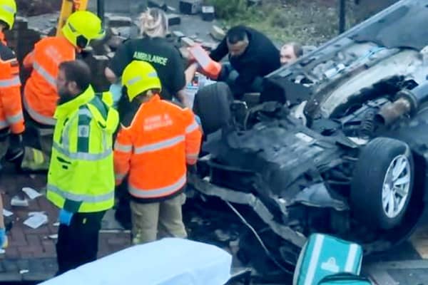 Footage of the aftermath of a car crash that left two pedestrians hospitalised shows a man being pulled from the wreckage.  