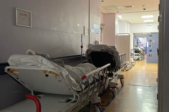 Patients wait in beds lining a hospital corridor at St Helier Hospital, Sutton, London.
