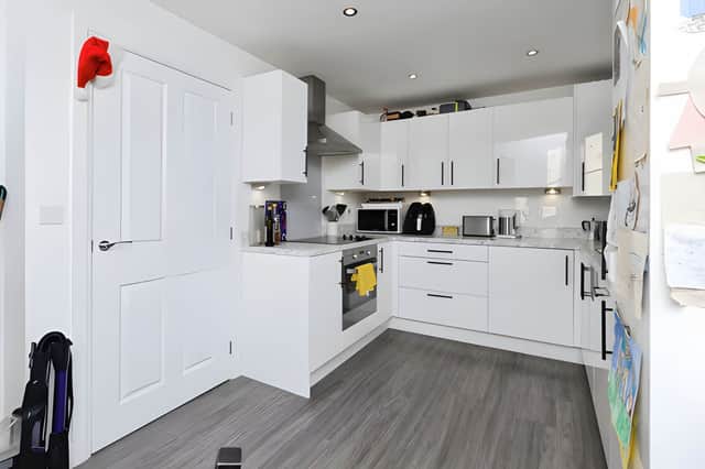 he modern kitchen and dining area forms a practical central space designed for everyday family life and entertaining