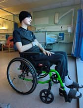 Josh sitting in a wheelchair in hospital for the first time.