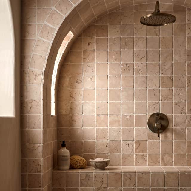 TIMELESS STYLE: Lapicida’s warm Rosa Perlino marble squares create a luxurious, Roman-inspired shower.