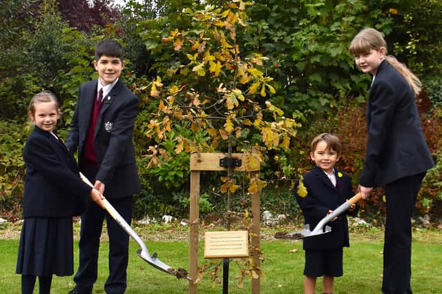 Pupils at Harrogate's Duchy College help plant the oak tree gifted to the school by the monarch.
