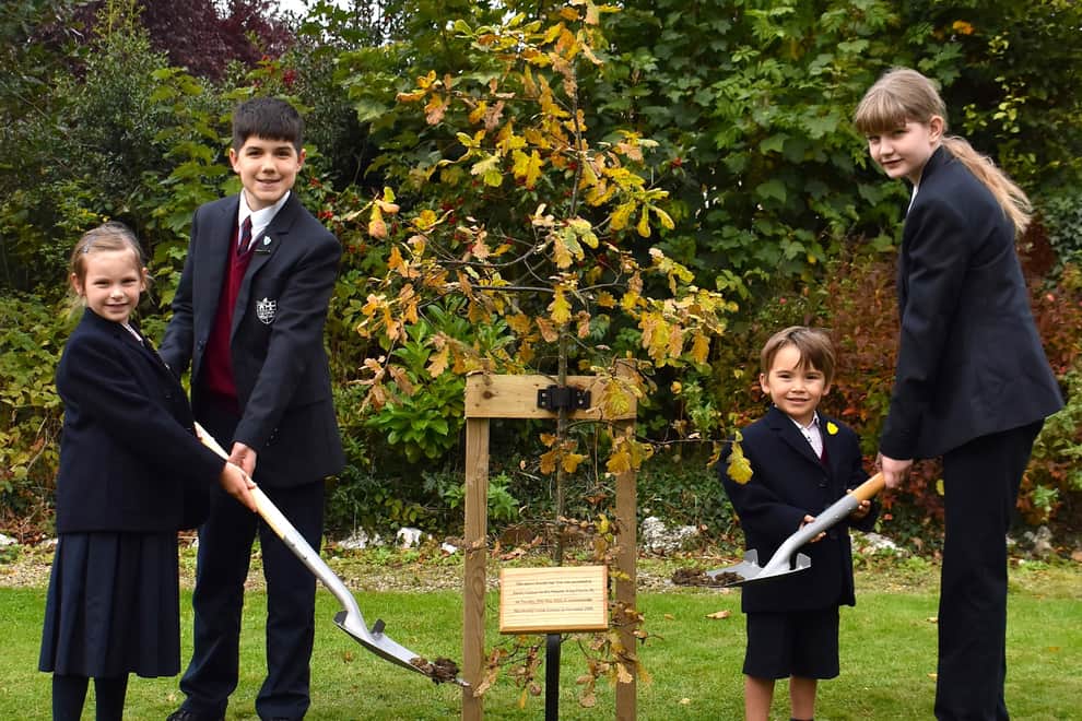 Pupils at Harrogate's Duchy College help plant the oak tree gifted to the school by the monarch.