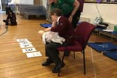 Starbeck St John Badger Stella demonstrating how to help a choking baby.