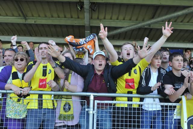 Some of the Harrogate Town FC fan base, young and older, show their passion at a match at CNG Stadium.