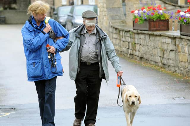 Roger Bealey on his  sponsored charity walk  around Wetherby blindfolded with guide dog Victoria  and Gail Skinner  a  Guide Dog Mobility Instructor in August 2012.