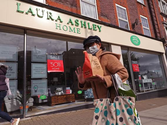 A woman wearing a face mask walking past a Laura Ashley store Picture: Yui Mok/PA Wire