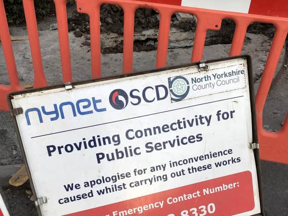 Work continues laying gigabit fibre (above) and a notice posted at an installation site