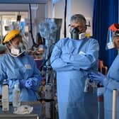 Clinical staff wear Personal Protective Equipment (PPE) as they care for a patient