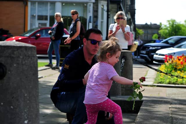 Two year old Rosa Moralee lays a rose after the two minutes silence at 11am. Picture Gerard Binks
