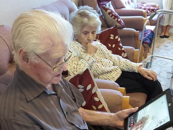 Les Kelly, 100, and Doris Kelly, 99, using an iPad to speak to their daughter.