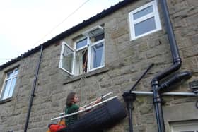 Harrogate mountaineer Victoria Morris hanging from a porta-ledge on the wall of her home. She is currently climbing the equivalent of the north face of the Eiger in aid of Mental Health Awareness Week.