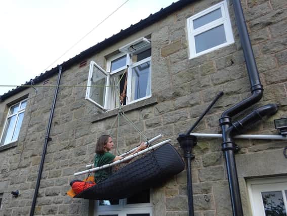 Harrogate mountaineer Victoria Morris hanging from a porta-ledge on the wall of her home. She is currently climbing the equivalent of the north face of the Eiger in aid of Mental Health Awareness Week.