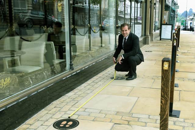 Luke Butler Deputy branch manager at Bettys in the Harrogate shop which is reopening on Monday, marking out the 2 metre spacing outside the shop. Picture: Gary Longbottom