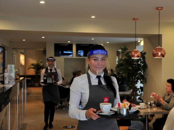 The 'new normal' as Harrogate's hospitality sector reopens - Pictured here are staff at Marconi cafe in Harrogate wearing PPE while serving. (Picture Gerard Binks)