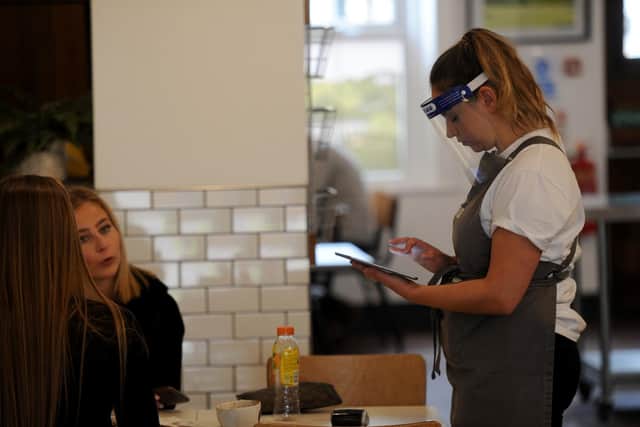 Safety first - Staff in PPE serving customers in Baltzersen's Coffee Shop, Oxford Street, Harrogate. Now customers will also have to wear face masks in takeway food areas.