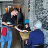 Supporting the the 'Eat Out to Help Out' discount scheme - Manager Lee Cooper serving customers in Starling Independent Bar cafe Kitchen on Oxford Street, Harrogate.