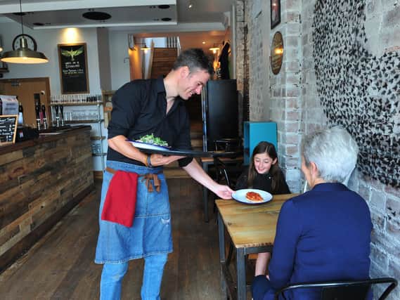 Supporting the the 'Eat Out to Help Out' discount scheme - Manager Lee Cooper serving customers in Starling Independent Bar cafe Kitchen on Oxford Street, Harrogate.