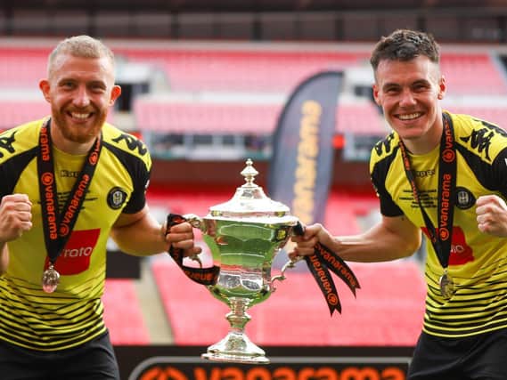 Harrogate Town's George Thomson, left, and Ryan Fallowfield with the National League play-off final winners' trophy. Picture: Matt Kirkham