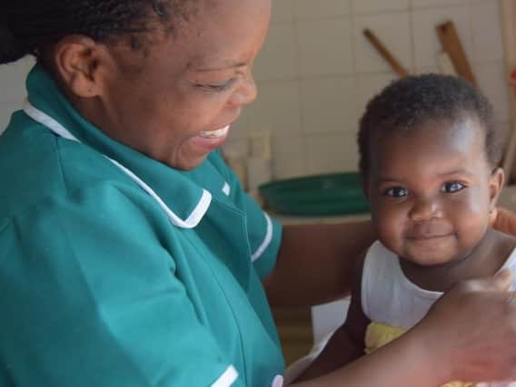 Harrogate charity's plea - An Open Arms staff member Eunice looks after little girl Tamala in Malawi.
