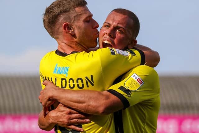 Aaron Martin receives a kiss from Jack Muldoon after setting his team-mate up to break the deadlock at Roots Hall.