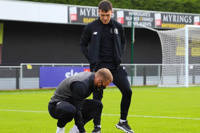 Town players George Thomson, left, and Ryan Fallowfield check out the new grass prior to kick-off.