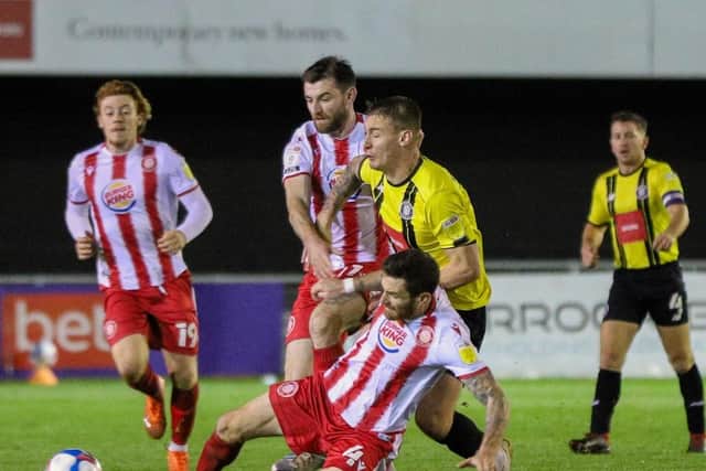 No way through: Town's Will Smith is crunched in a challenge by Stevenage midfielder Romain Vincelot.