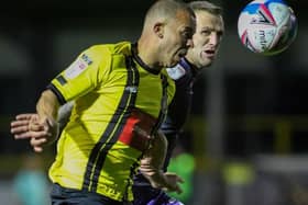 Harrogate Town striker Aaron Martin looks to run away from Tranmere centre-half Peter Clarke. Pictures: Matt Kirkham