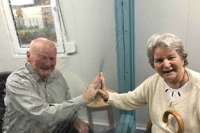 Vida Grange care homes' new visitor pods in Harrogate include a tactile vinyl wall which brings loved ones together, safely, in this case, Michael and Patricia Boddington.