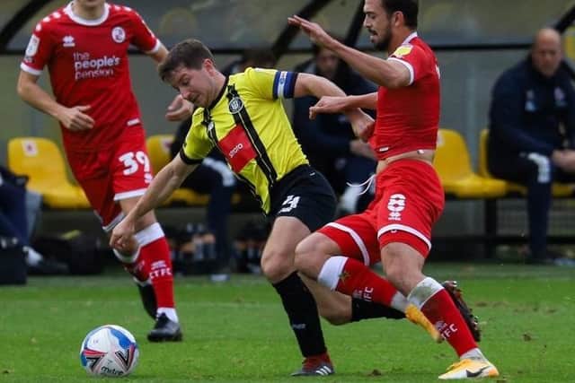 Harrogate skipper Josh Falkingham is challenged by Crawley's Jack Powell.
