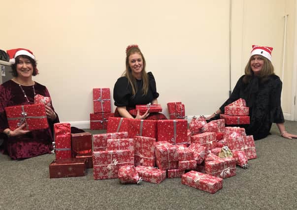 Supporting Older People (SOP) staff wrap presents for distribution to needy clients.