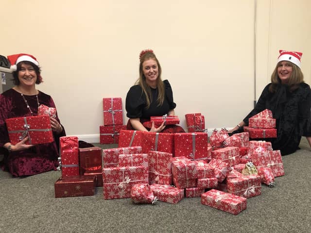Supporting Older People (SOP) staff wrap presents for distribution to needy clients.