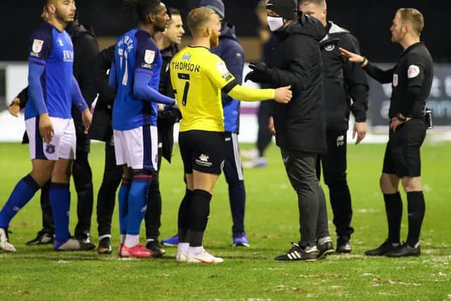 Players and staff from both sides confront the match officials following the decision to abandon Harrogate Town's clash with Carlisle United. Picture: Matt Kirkham