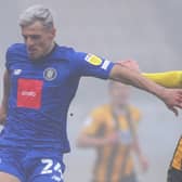 Harrogate Town striker Josh March holds off Cambridge United's Harry Darling. Pictures: Matt Kikrham