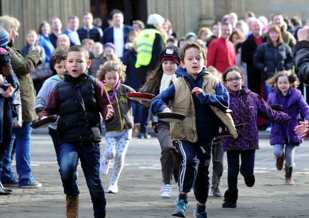 17/2/15    Youngsters taking part in one of the many  the pancake races  from Ripon Cathedral on Shrove Tuesday is given a helping hand .(GL1005/03u)