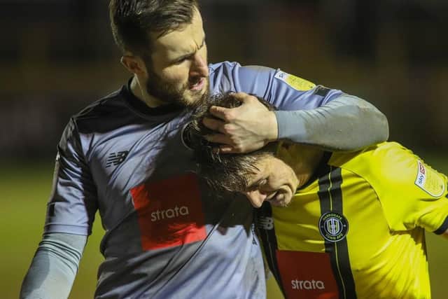 Harrogate Town goalkeeper James Belshaw celebrates his clean-sheet with defender Will Smith.