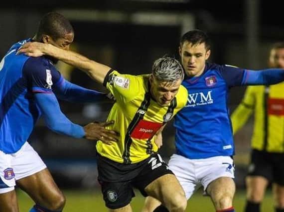 Harrogate Town striker Josh March looks to escape the attentions of two Carlisle United players. Picture: Matt Kirkham