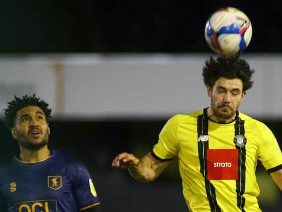 Harrogate Town centre-half Connor Hall heads the ball clear during his side's midweek win over Mansfield. Pictures: Matt Kirkham