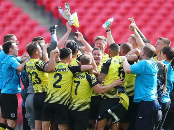 Harrogate Town players and staff celebrate on the Wembley turf following their 2019/20 National League play-off final success over Notts County. Picture: Getty Images