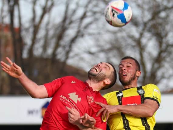 Harrogate Town striker Aaron Martin competes in the air with Morecambe's Alex Kenyon. Pictures: Matt Kirkham