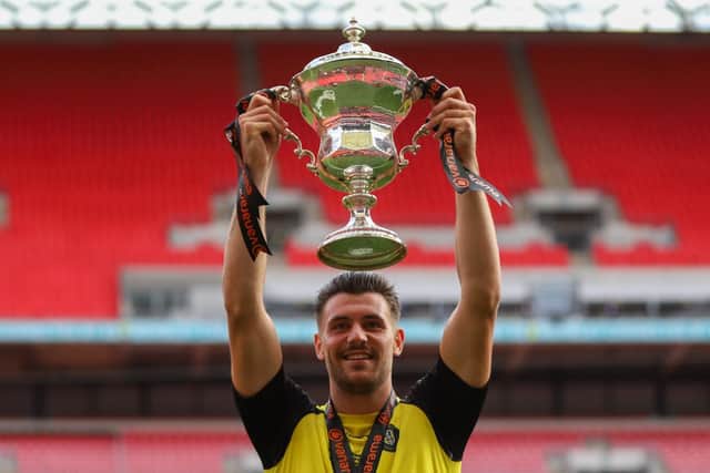 Connor Hall with the 2020 National League play-off final winners' trophy at Wembley Stadium.