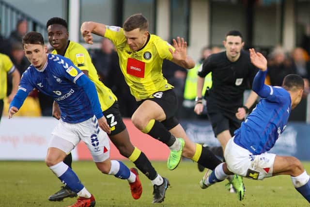 Hat-trick hero Jack Muldoon bursts past two Latics defenders.