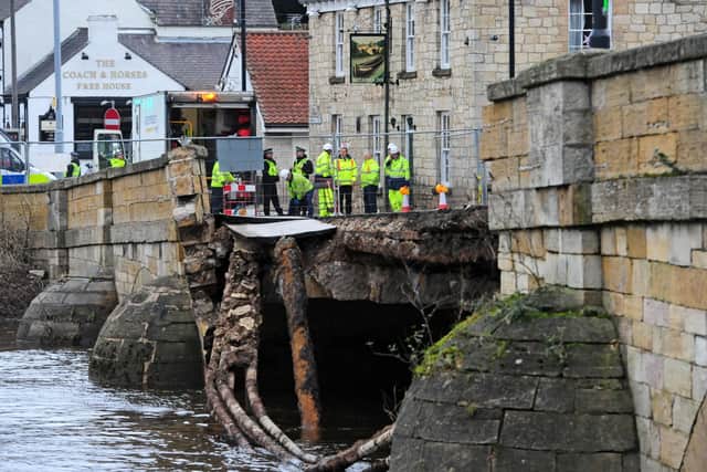 Police and Agency staff stand at the entrance to the historic Tadcaster Bridge which has partially collapsed. Picture: Anthony Chappel-Ross