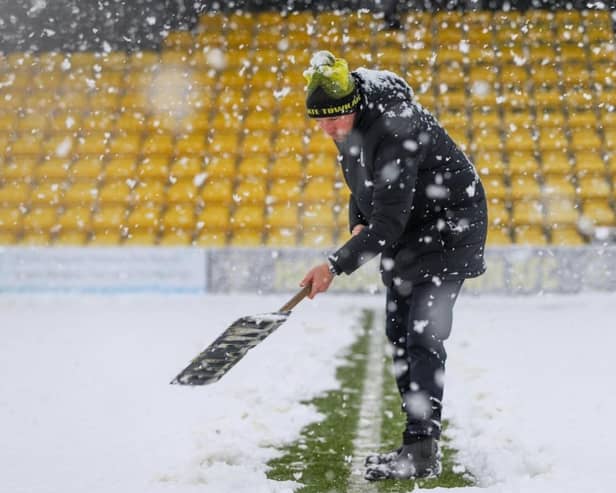 Harrogate Town staff and volunteers attempted to clear the EnviroVent Stadium pitch of snow ahead of Saturday's scheduled League Two fixture with Leyton Orient.  Pictures: Matt Kirkham