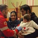 Helping refugees - A Red Cross medic in Poland helping a family newly arrived from Ukraine.